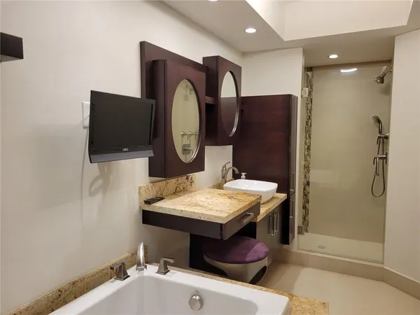 a bathroom with a tub sink and mirror