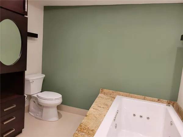 a white toilet sitting next to a bathroom sink