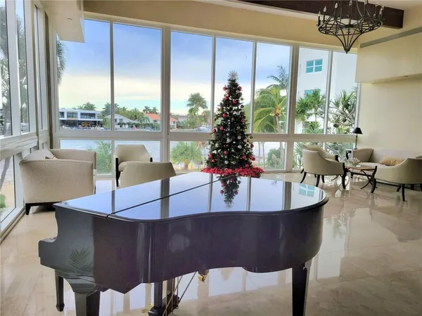 a living room with furniture potted plant and a large window