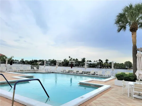 a view of swimming pool with outdoor seating and city in back