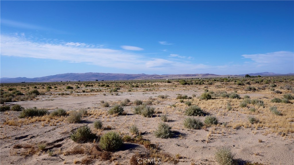 0 Friends Road Hinkley, CA 92347 - Photo 2 of 9 a view of a dry yard with mountains in the background