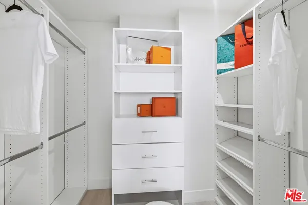 a view of hallway with walk in closet and window