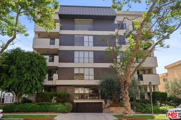 a front view of a residential apartment building with a yard