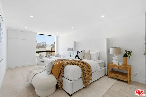 a spacious bedroom with a bed and a large window