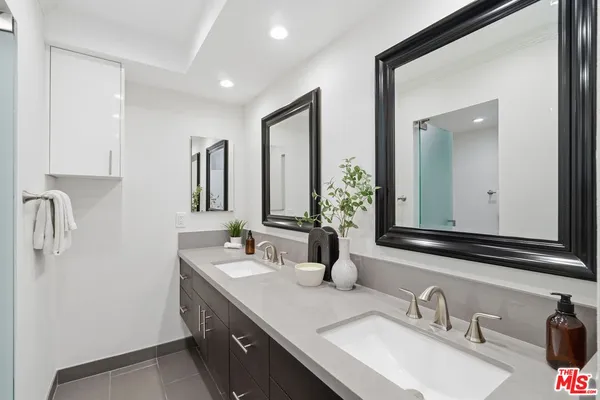 a bathroom with double vanity sinks and a mirror
