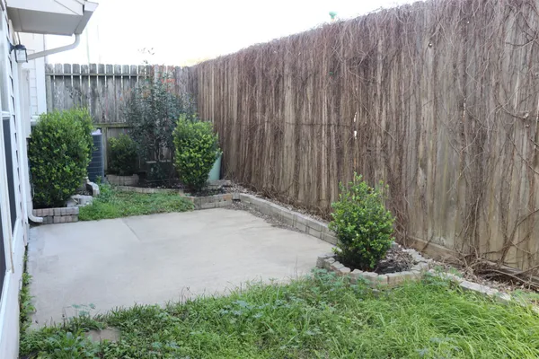 a view of a backyard with plants and wooden fence
