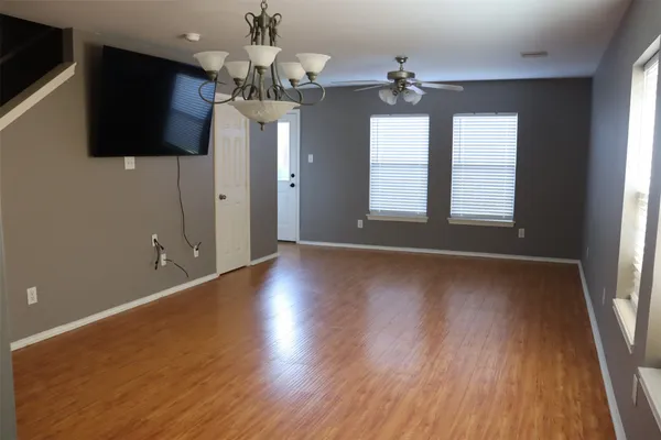 a view of a livingroom with a flat screen tv wooden floor and a window