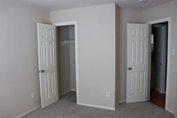 an empty room with closet and wooden door