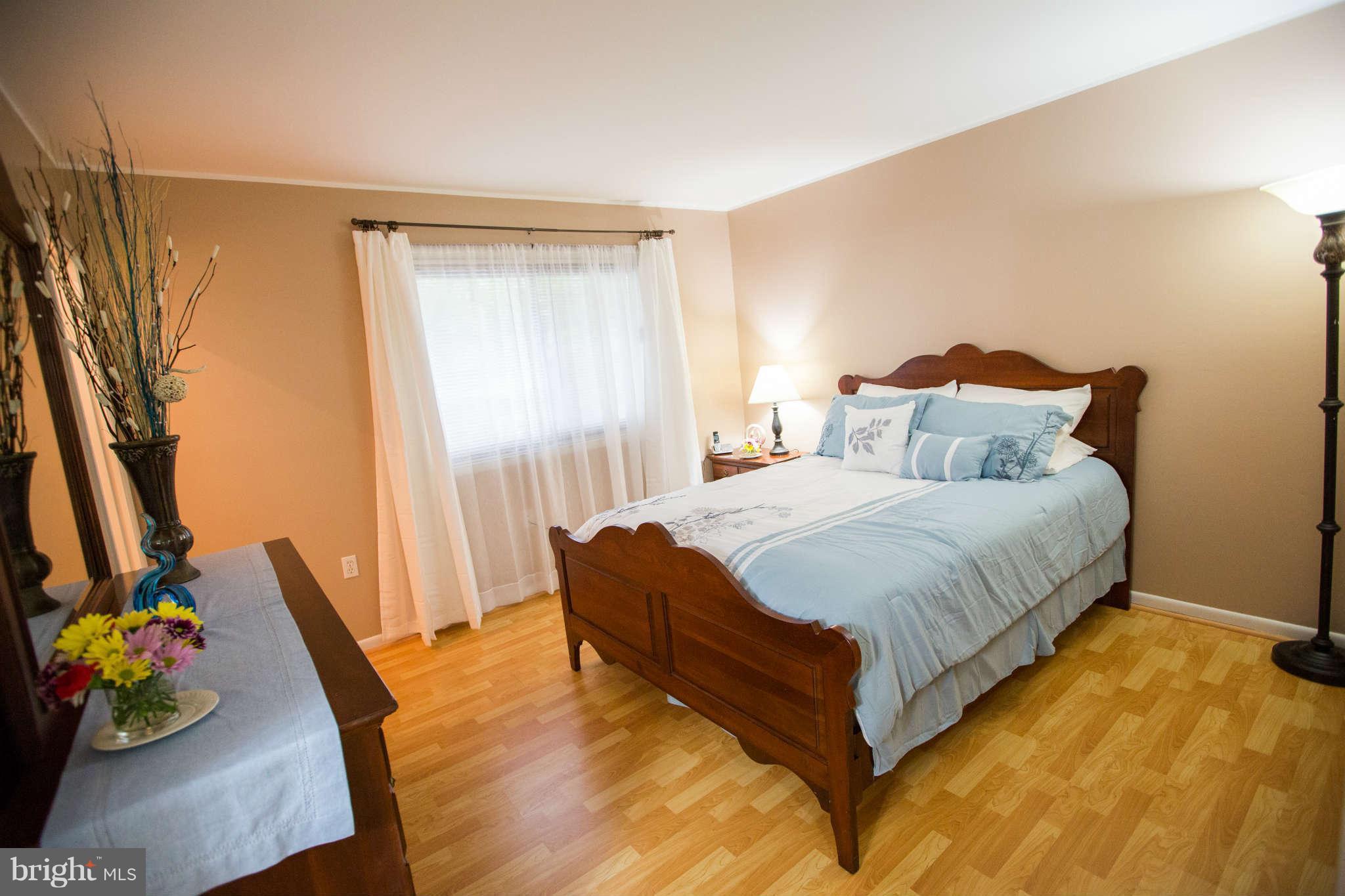 2226 Lofty Heights Place Reston, VA 20191 - Photo 9 of 25 a bedroom with a bed and dresser with wooden floor