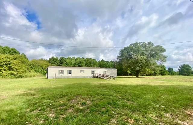 a view of a big yard with large trees and a big yard