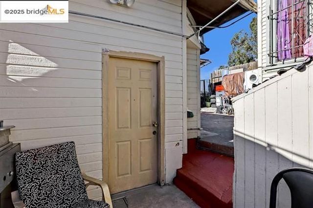 an empty room with wooden floor chandelier fan and windows