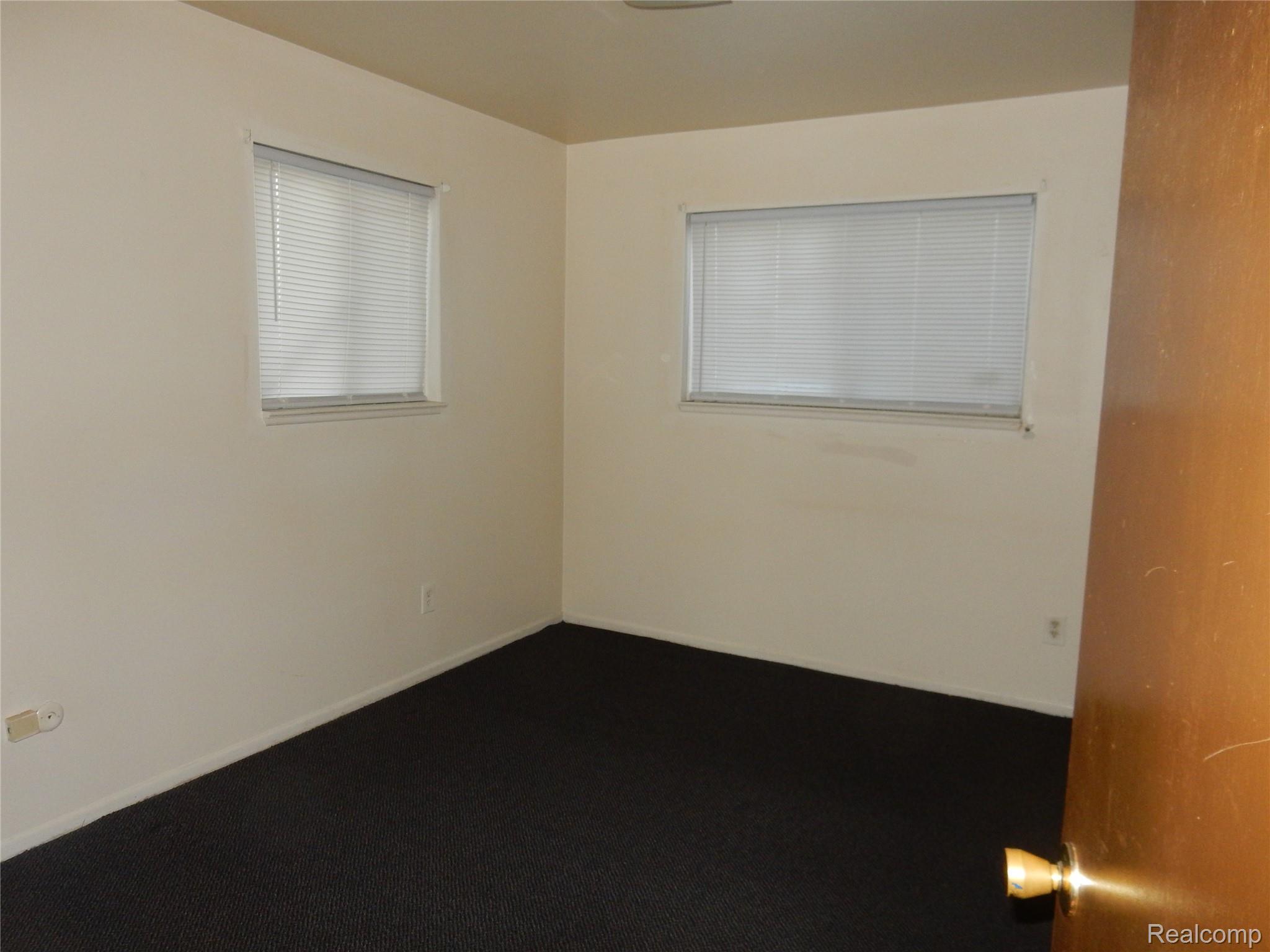 150 Arcola Street, Unit 3 Inkster, MI 48141 - Photo 9 of 15 Spare room featuring dark colored carpet and baseboards