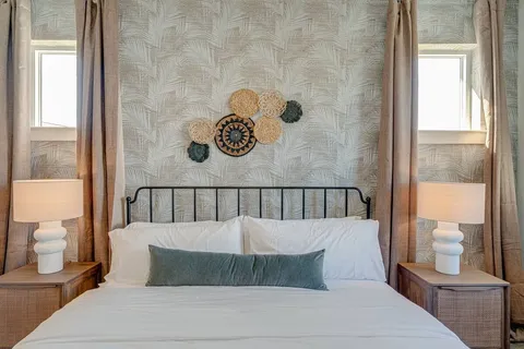 a bedroom with a large bed and a painting on the wall