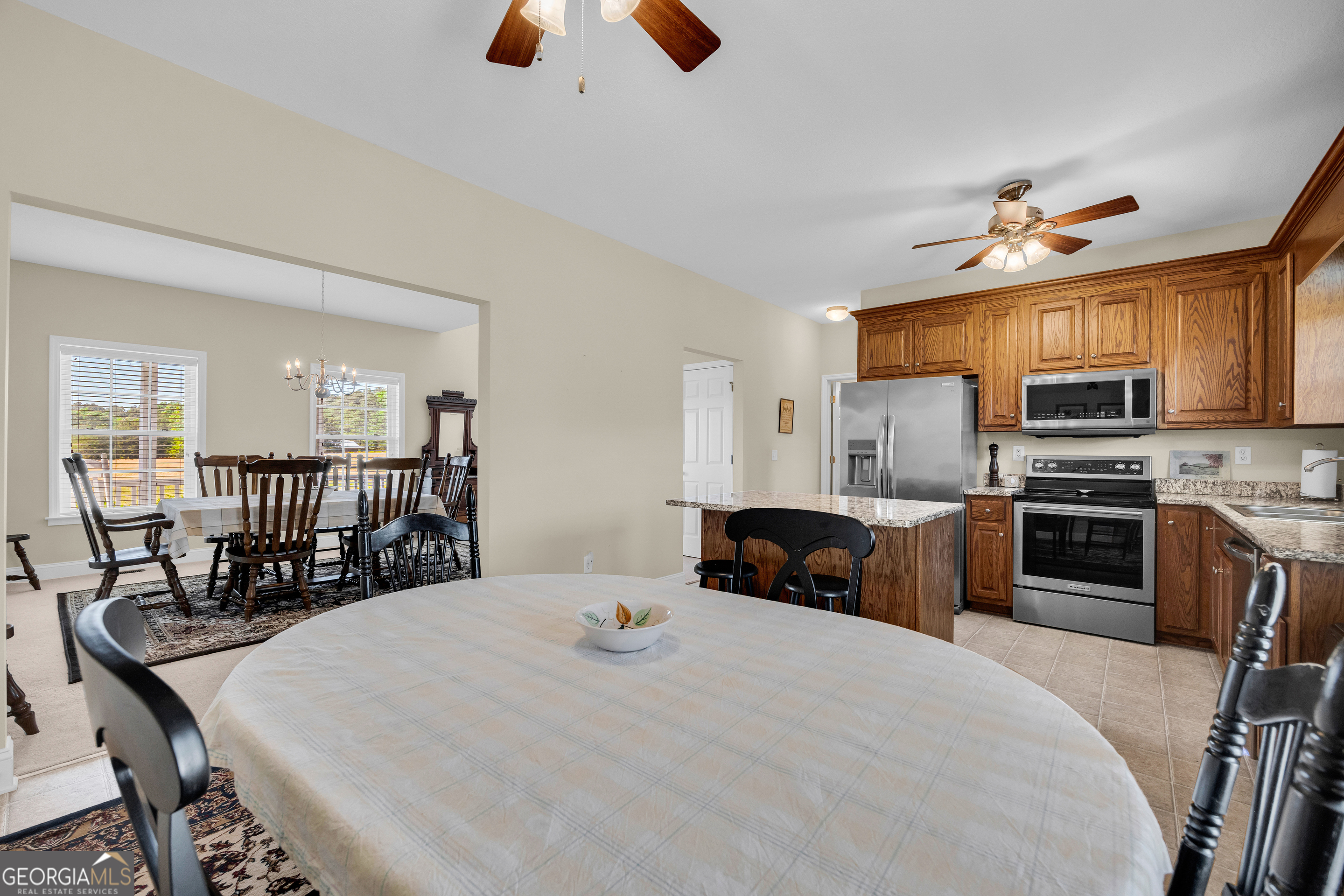 3248 Metasville Road Washington, GA 30673 - Photo 33 of 97 a kitchen with stainless steel appliances granite countertop a stove a refrigerator a oven a sink with a dining table and chairs