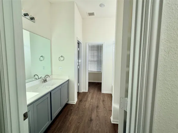 a spacious bathroom with a double vanity sink a mirror and a shower