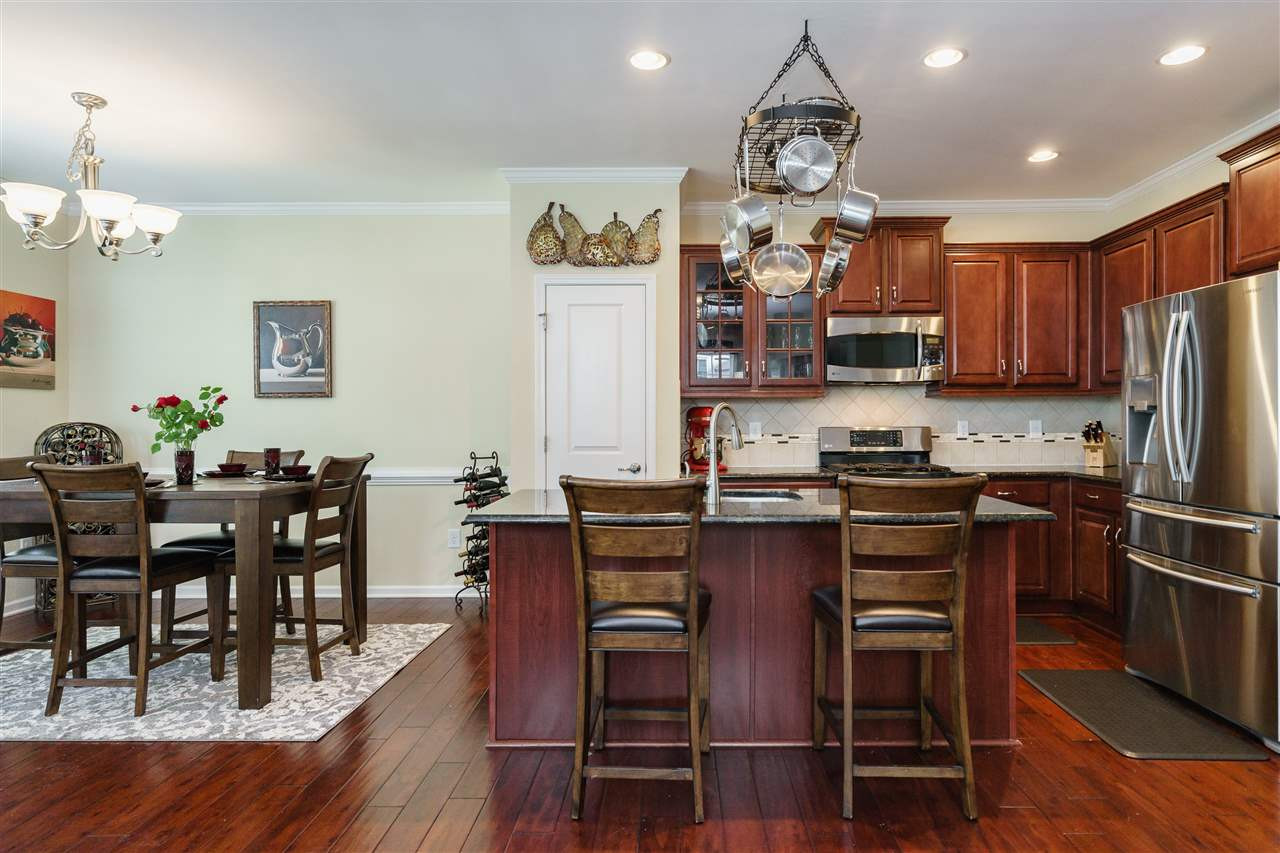5622 Wade Park Boulevard Raleigh, NC 27607 - Photo 9 of 25 BEAUTIFUL KITCHEN WITH HARDWOOD CABINETS, GRANITE COUNTERTOPS, SS APPLIANCES AND ISLAND/BAR AREA---OPEN TO DINING ROOM AND LIVING ROOM CREATING A SPACIOUS FEEL DOWNSTAIRS. KITCHEN