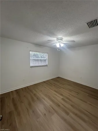 a view of an empty room and chandelier fan