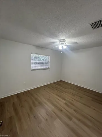 a view of an empty room and chandelier fan