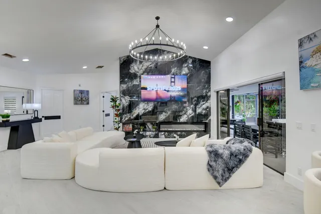 a living room with furniture a chandelier and a painting