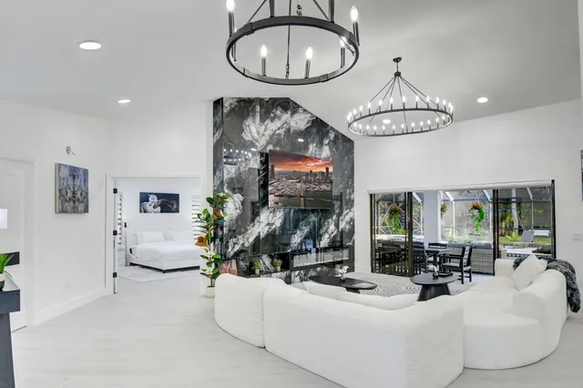 a kitchen with stainless steel appliances granite countertop a sink a refrigerator and chairs