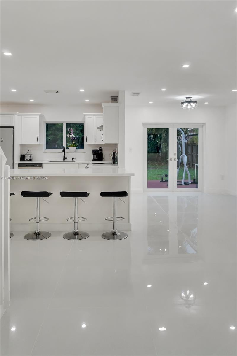 15309 Southwest 183rd Terrace Miami, FL 33187 - Photo 11 of 30 a large white kitchen with kitchen island a sink a stove and a refrigerator