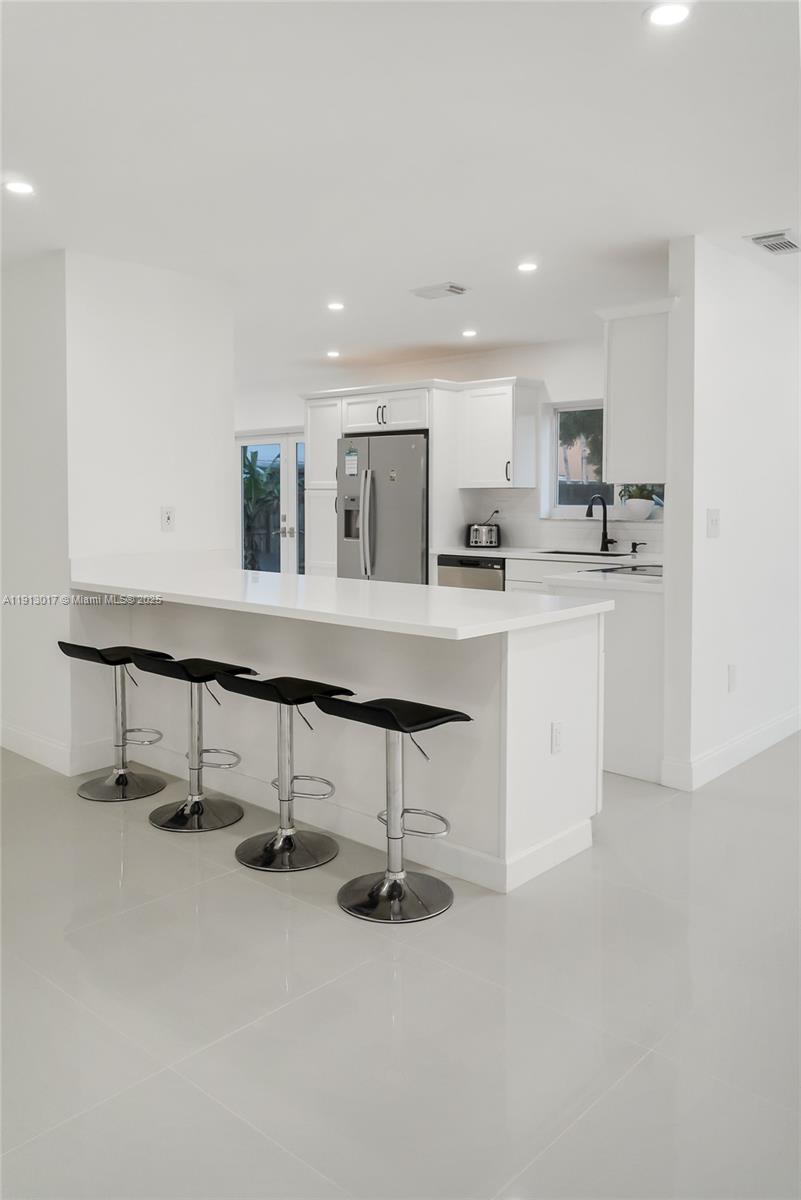 15309 Southwest 183rd Terrace Miami, FL 33187 - Photo 12 of 30 a kitchen with kitchen island cabinets and window