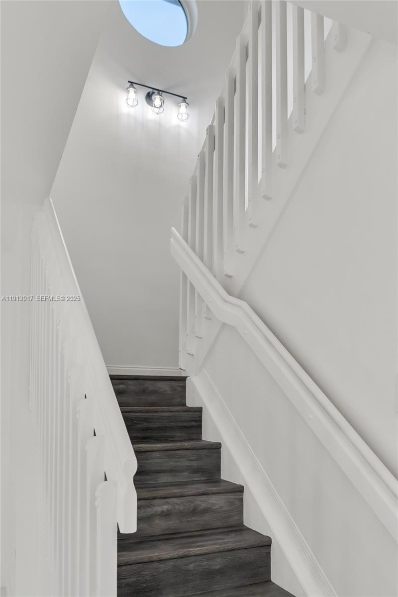 15309 Southwest 183rd Terrace Miami, FL 33187 - Photo 17 of 30 a view of staircase with lots of frames on wall and wooden floor