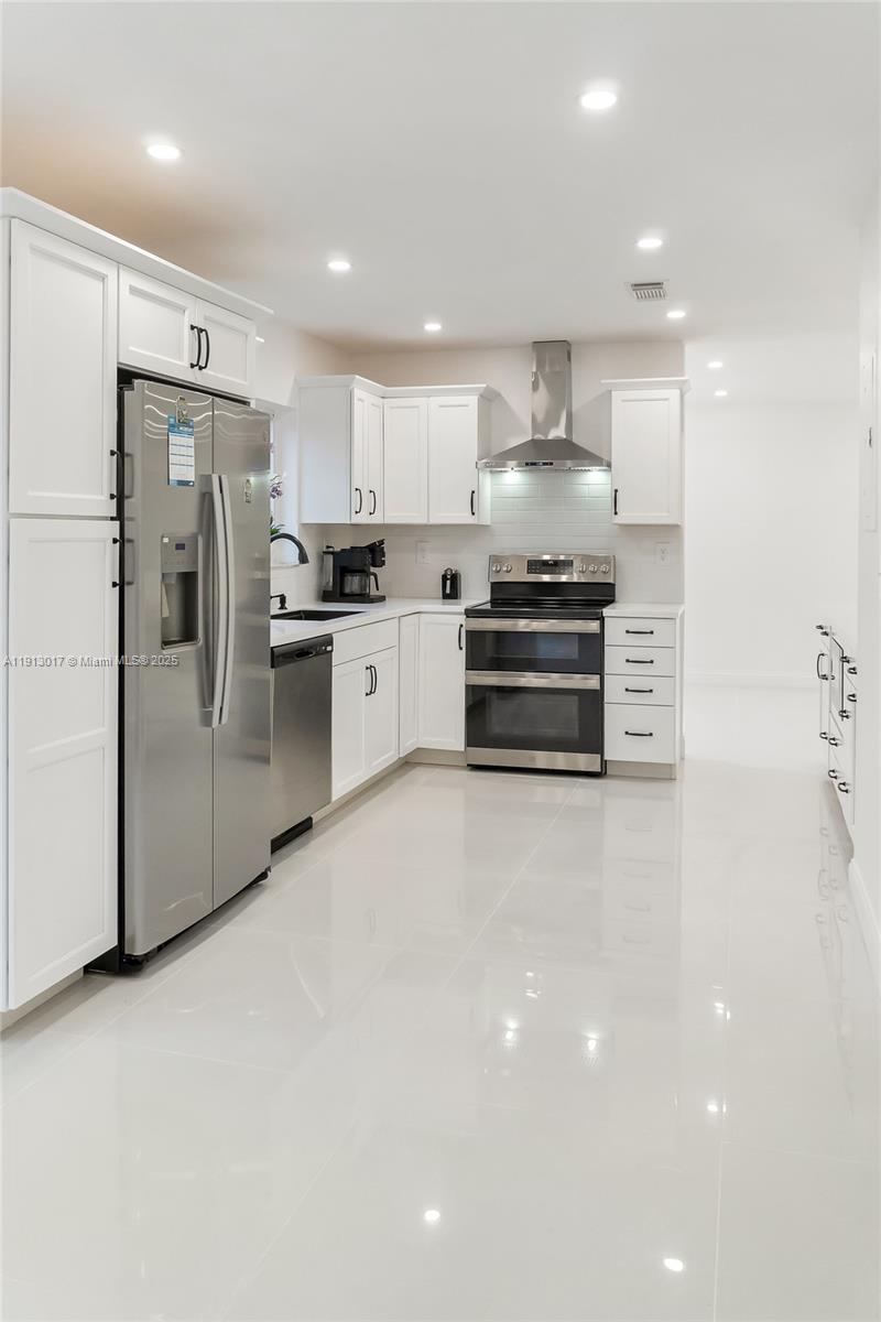 15309 Southwest 183rd Terrace Miami, FL 33187 - Photo 6 of 30 a large kitchen with stainless steel appliances and a refrigerator