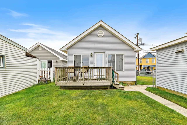 a view of a house with a yard and deck