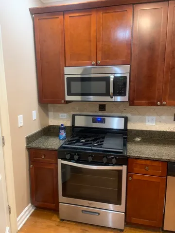 a kitchen with granite countertop stainless steel appliances and cabinets