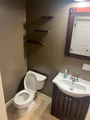 a bathroom with a toilet a sink and mirror
