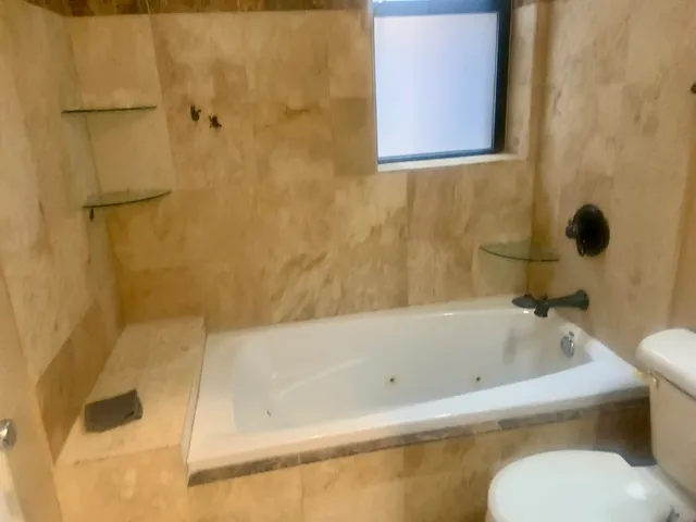 a bathroom with a tub and a shower