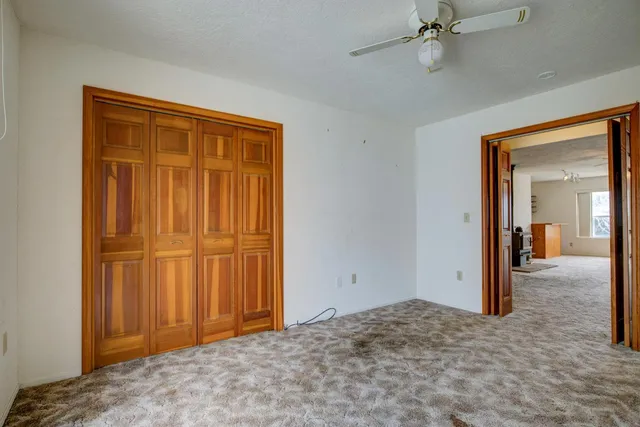 a view of empty room with window and ceiling fan