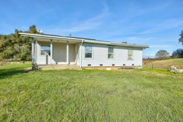 a view of backyard with swimming pool and green space