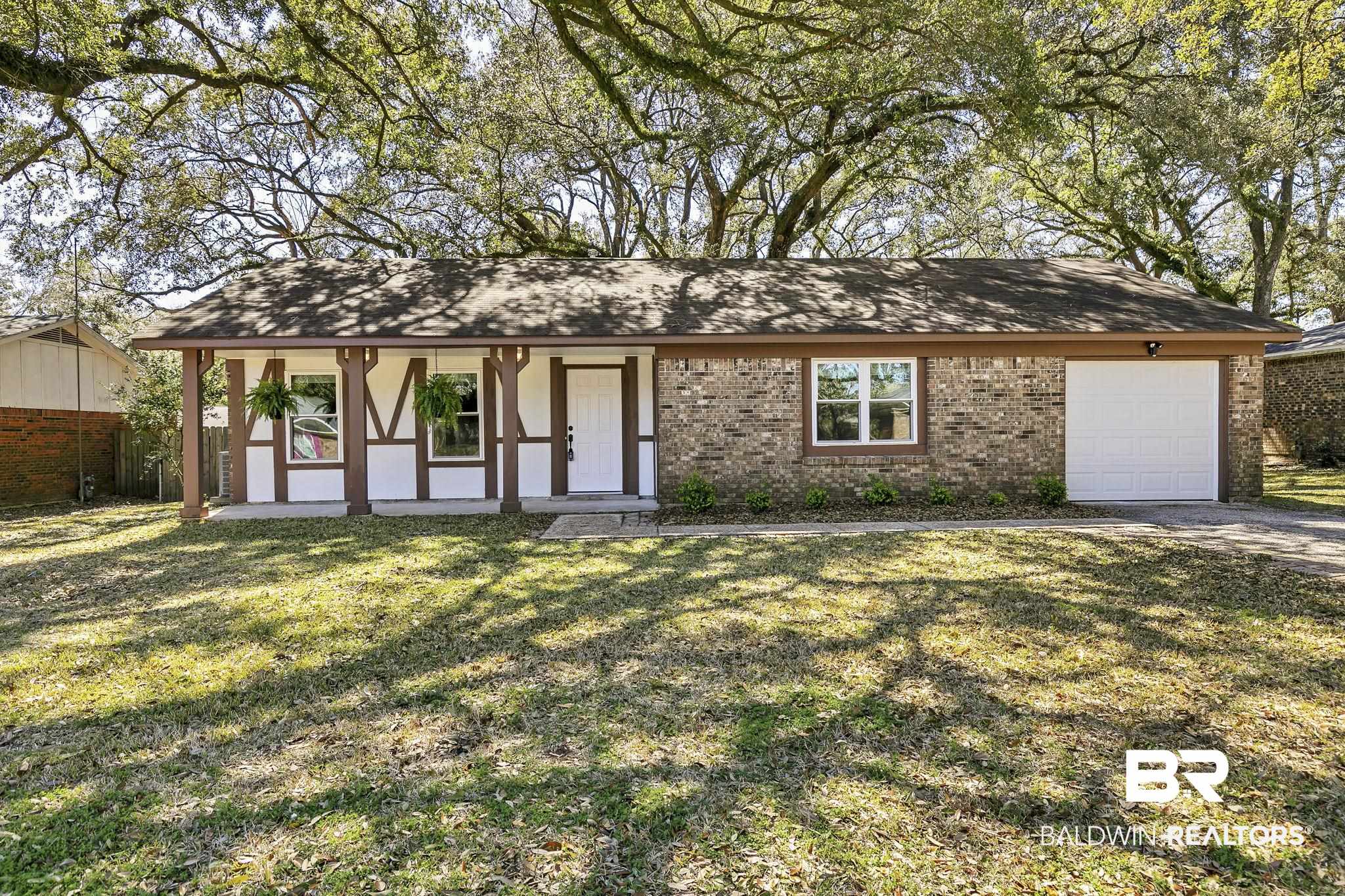 5817 Woodgate Road Mobile, AL 36609 - Photo 1 of 85 View of front of property with a garage, a front yard, brick siding, and fence