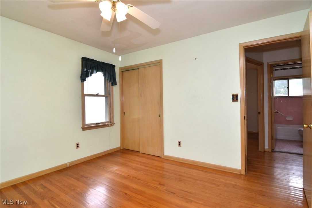 9421 David Road Cleveland, OH 44125 - Photo 23 of 36 Unfurnished bedroom with multiple windows, light wood-type flooring, a closet, and a ceiling fan