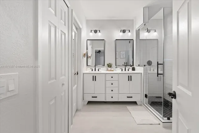 a bathroom with a double vanity sink a mirror a window and a shower