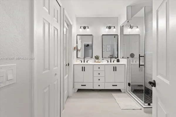 a bathroom with a double vanity sink a mirror a window and a shower