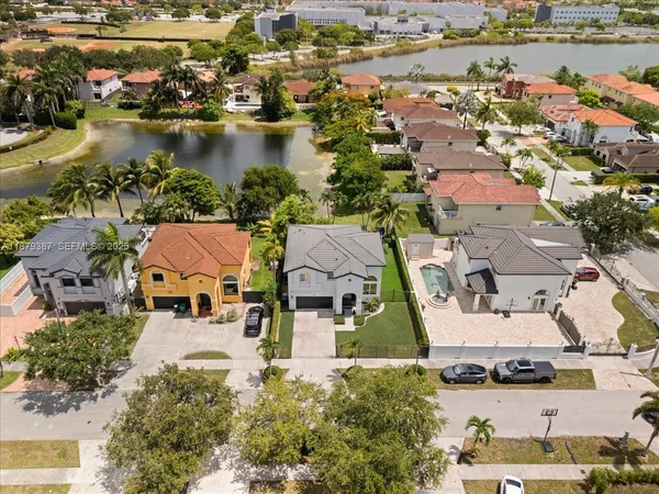 an aerial view of residential houses with outdoor space and lake view