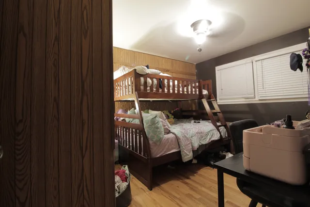 a bedroom with a bed and wooden floor