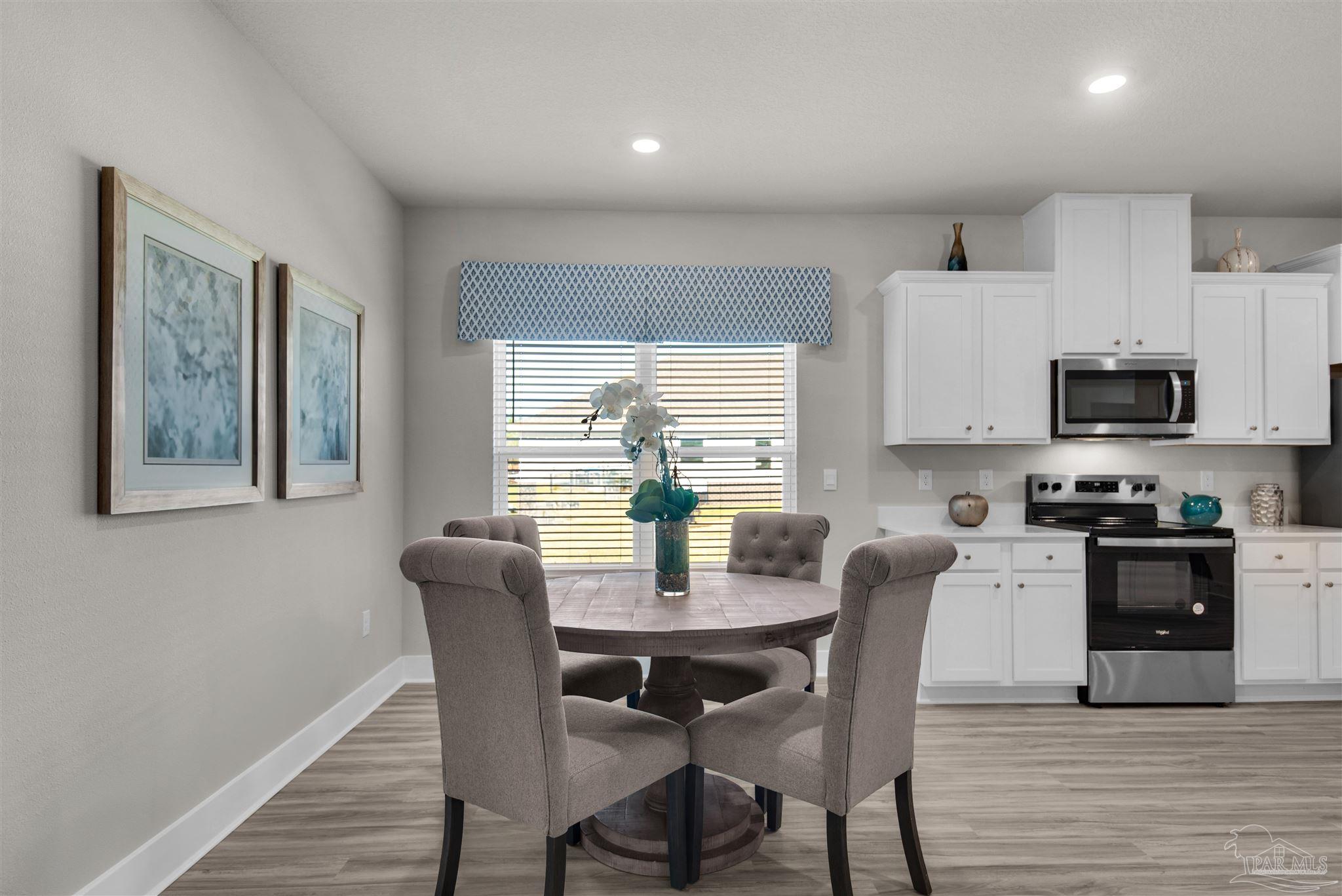 5658 Clarity Street Milton, FL 32570 - Photo 17 of 37 a view of a dining room with furniture window and wooden floor