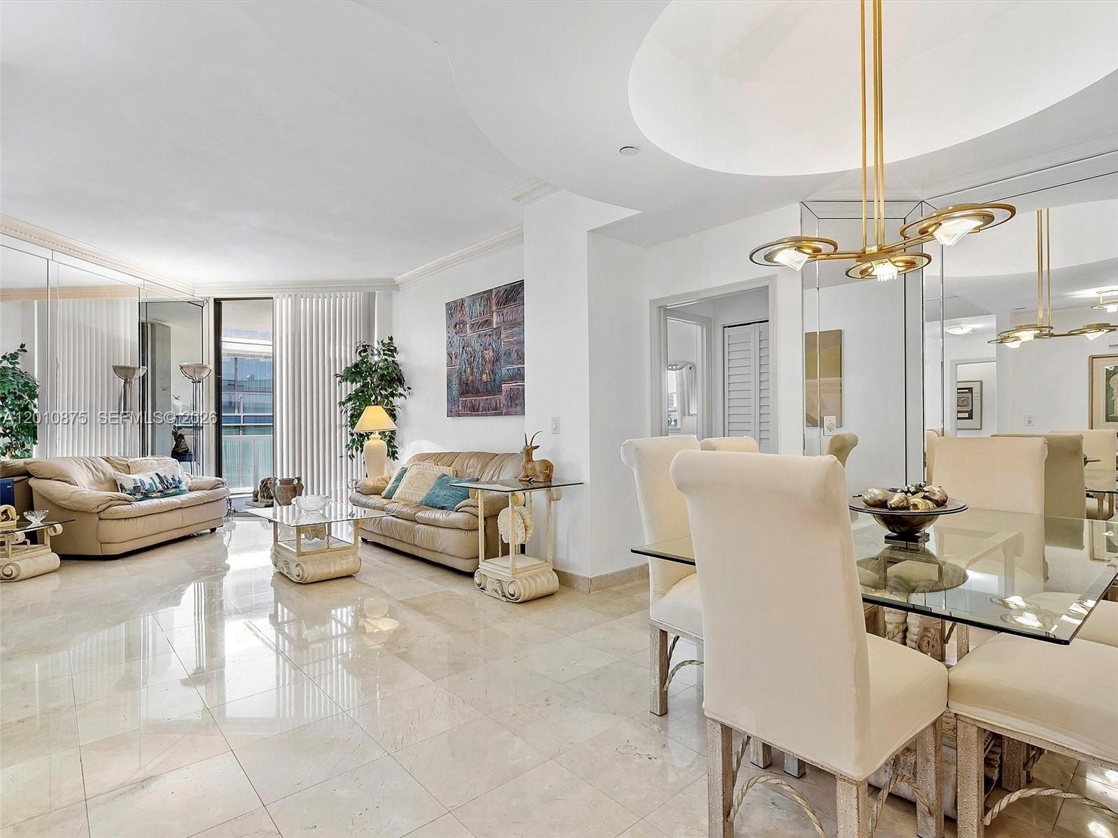 8925 Collins Avenue, Unit 12D Surfside, FL 33154 - Photo 4 of 35 a living room with furniture and a chandelier