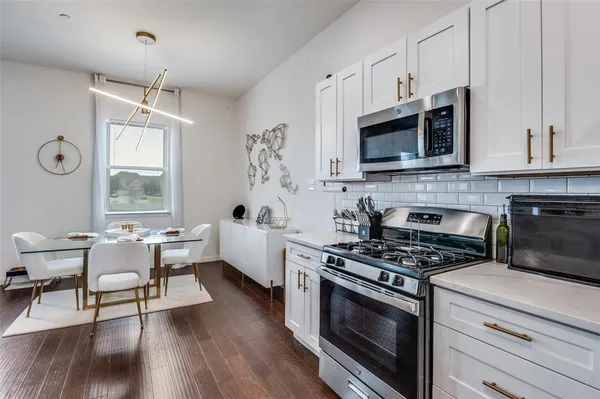 a kitchen with stainless steel appliances a white stove top oven and a white cabinets