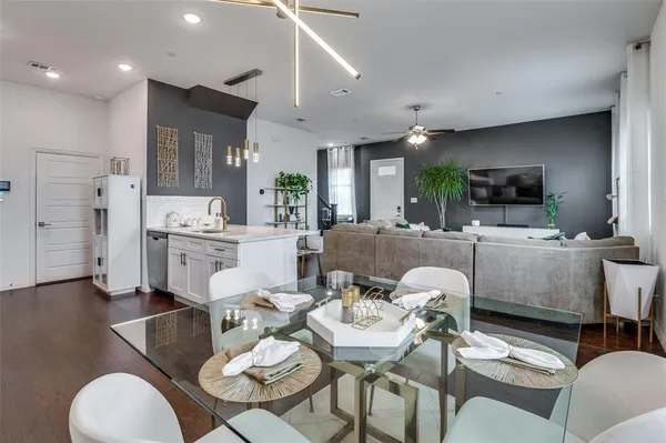 a living room with furniture kitchen view and a wooden floor
