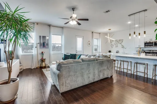 a living room with furniture and a wooden floor