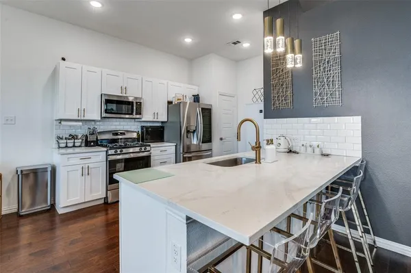 a kitchen with kitchen island a sink appliances and cabinets