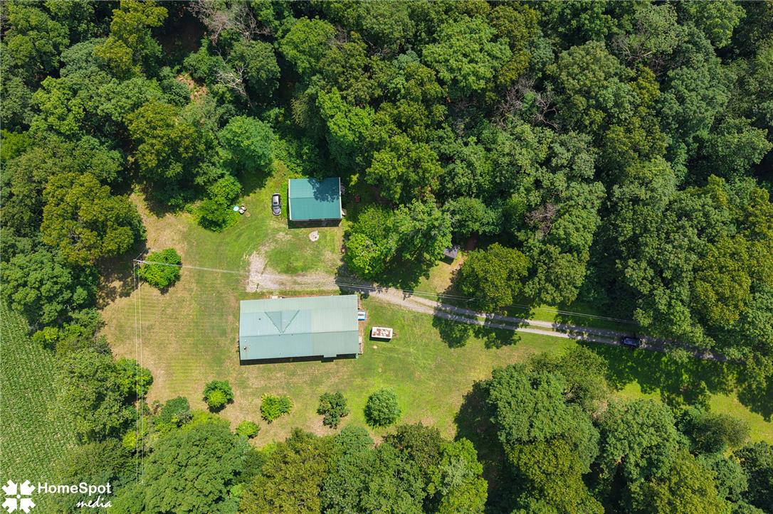 3795 Rhoades Road Kempton, PA 19529 - Photo 3 of 42 An aerial perspective reveals a serene, wooded estate with multiple structures nestled among lush green foliage.