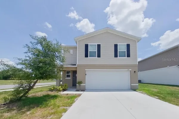 a front view of a house with a yard and garage