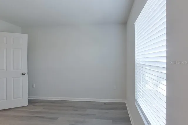 a view of a small space with wooden floor and a window
