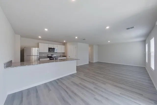 a large kitchen with a large counter top appliances and cabinets